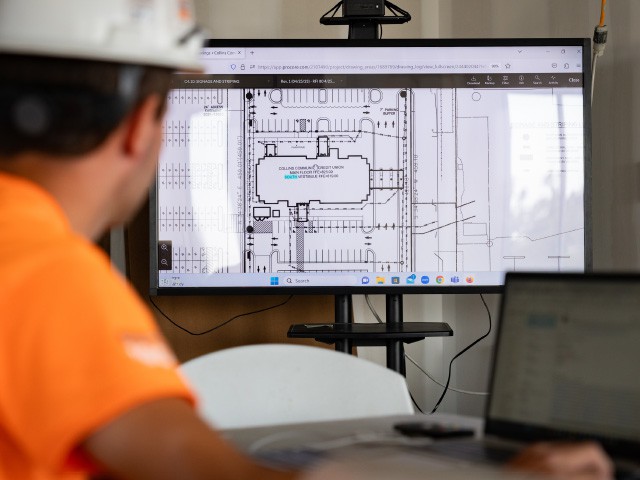 Conlon Construction worker looking at blueprints on computer